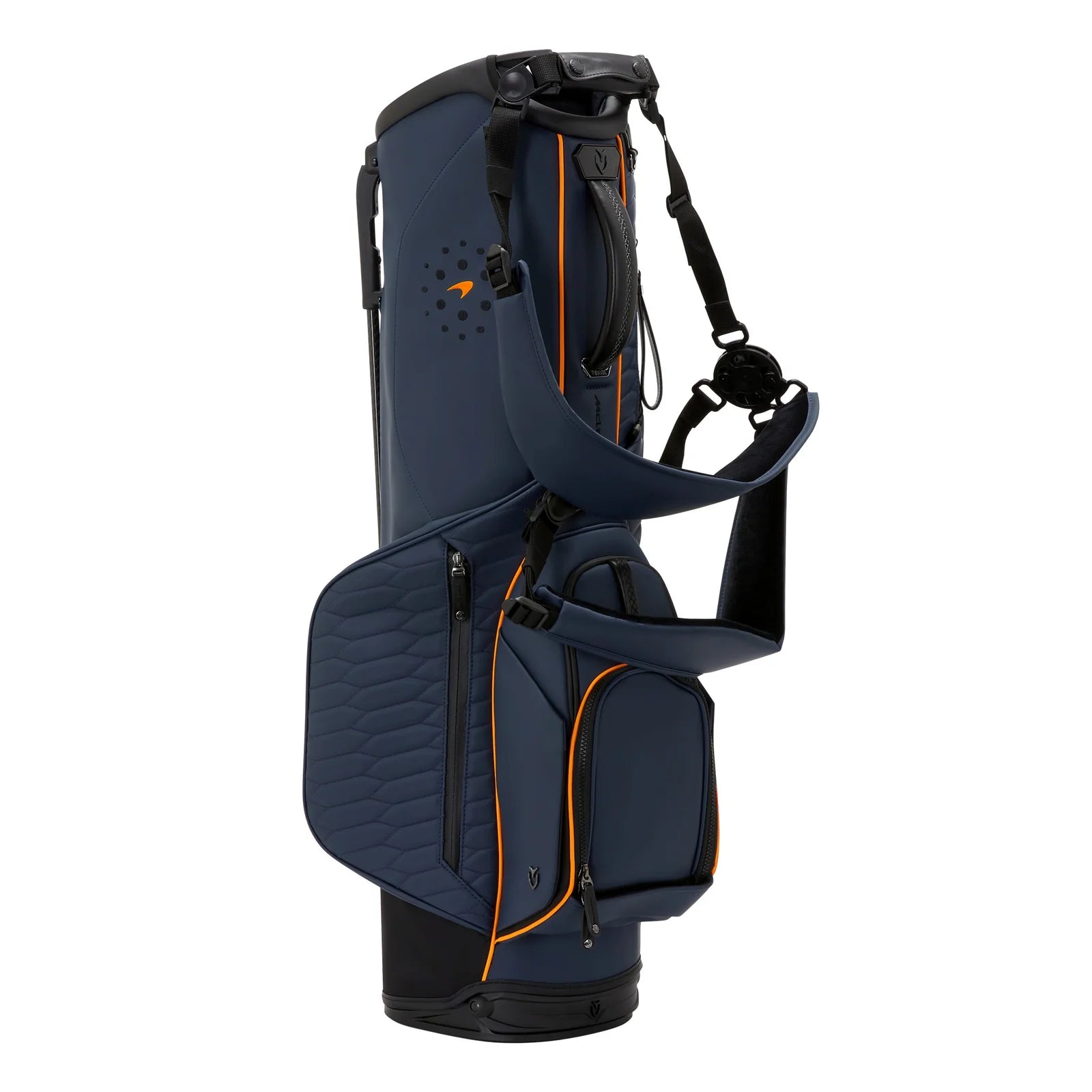 A luxury Vessel golf bag featuring McLaren branding standing next to a Ferrari V12 supercar.